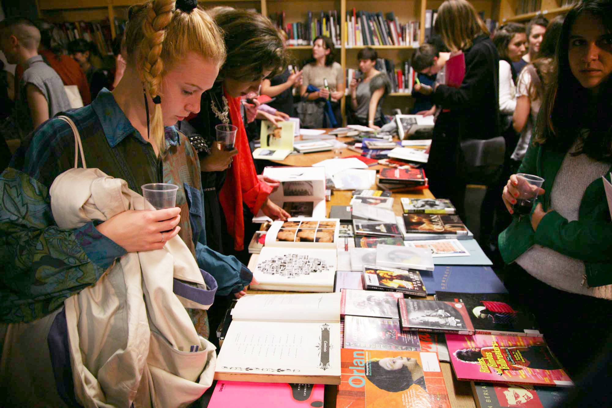 A group of Study Room users look at a table full of books in LADA's Study Room.