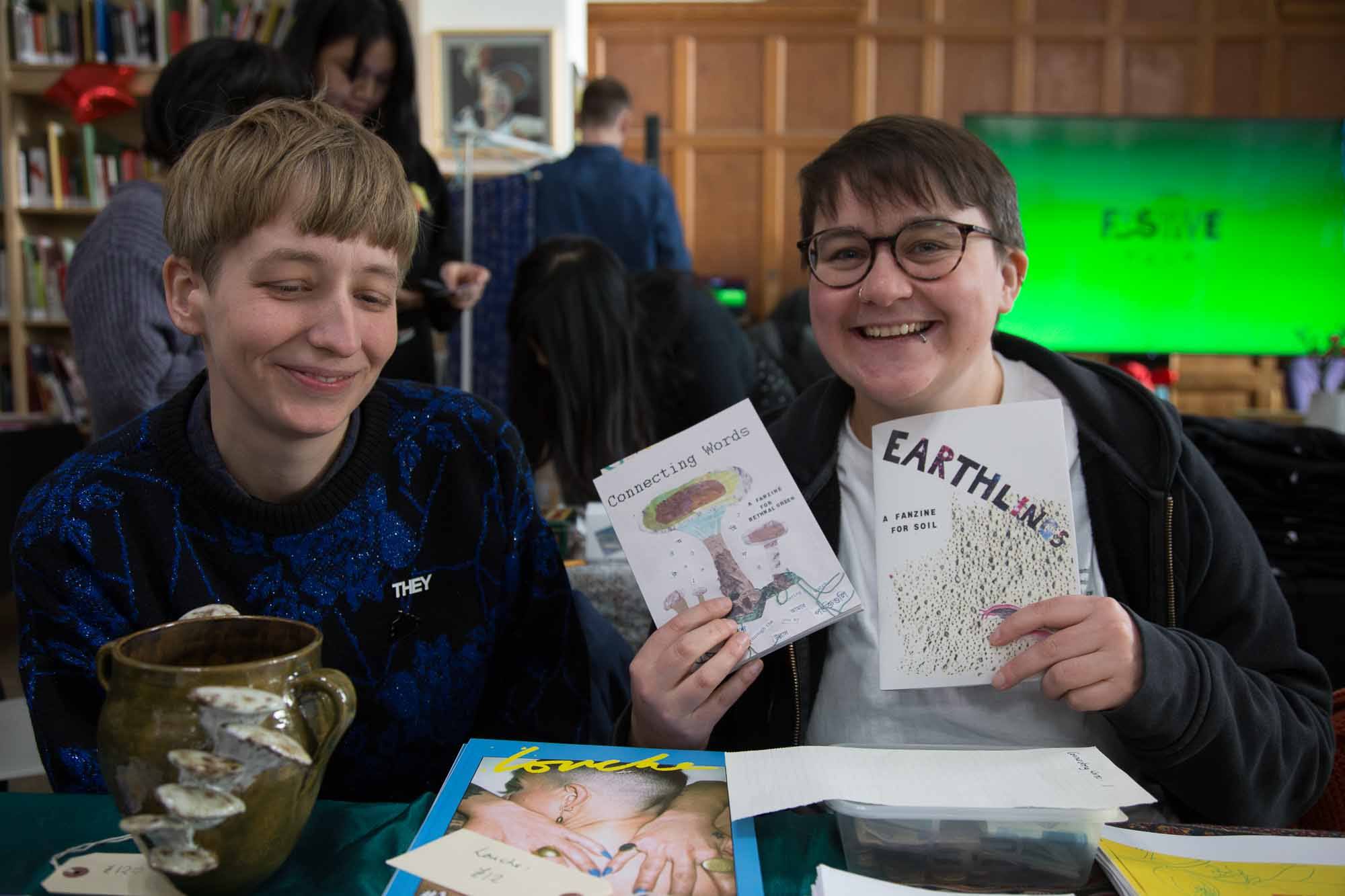 Two stall holders display their zines.